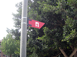 Flecha pequea, solo con inscripcin del logo, colocada en farolas en tramos urbanos